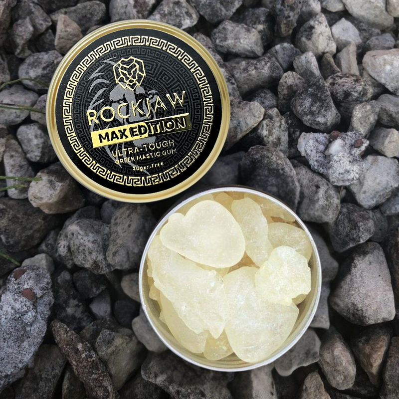 Two ROCKJAW MAX Edition tins of mastic gum on grey stones